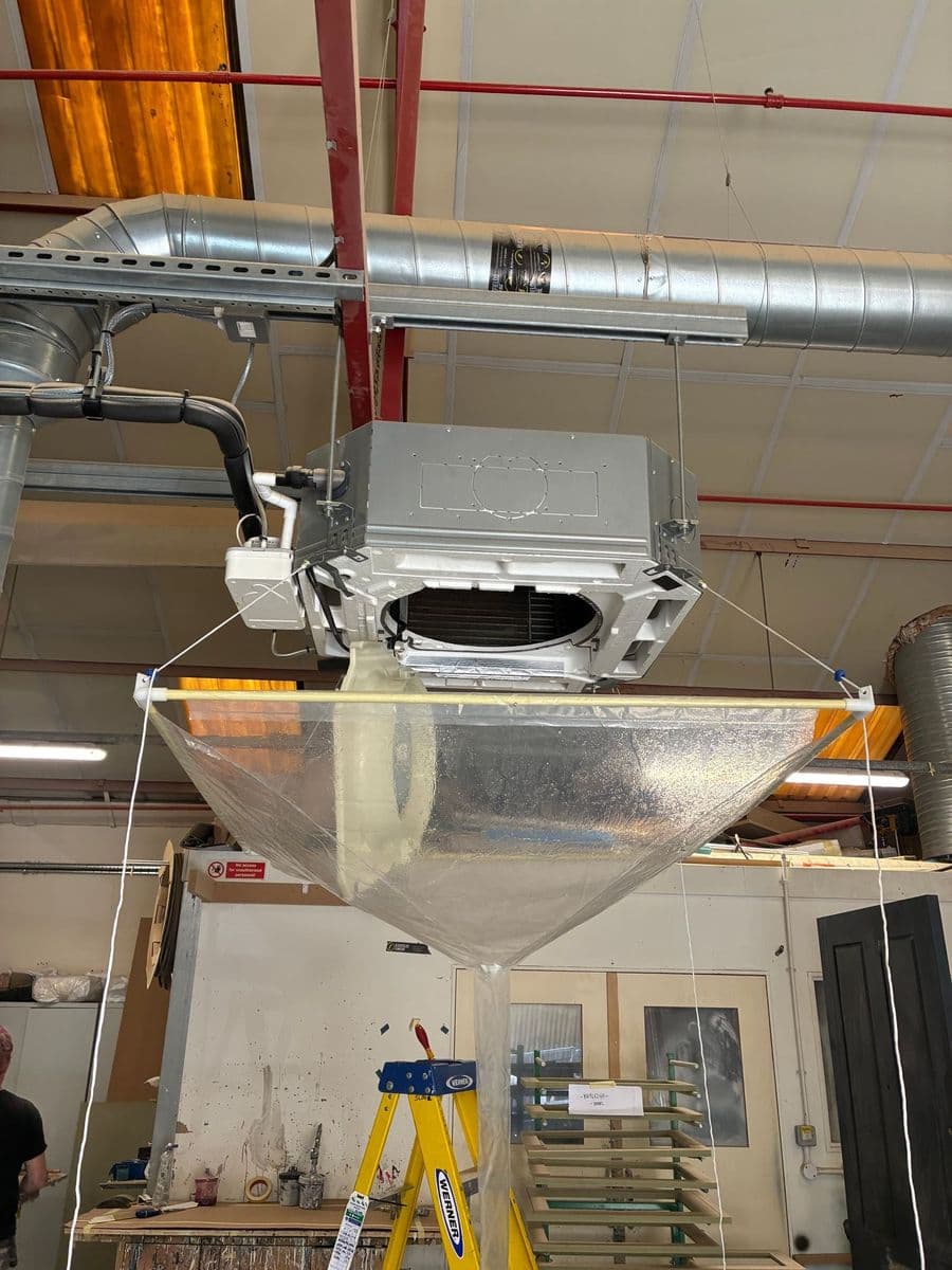 Commercial cassette air conditioning unit being installed in a workplace ceiling