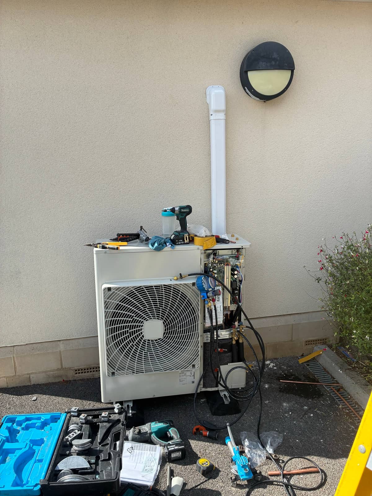Outdoor air conditioning condenser with service gauges and tools during installation
